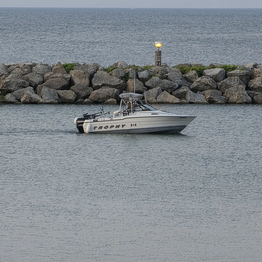 Boat beside an Ontario breakwall on open water