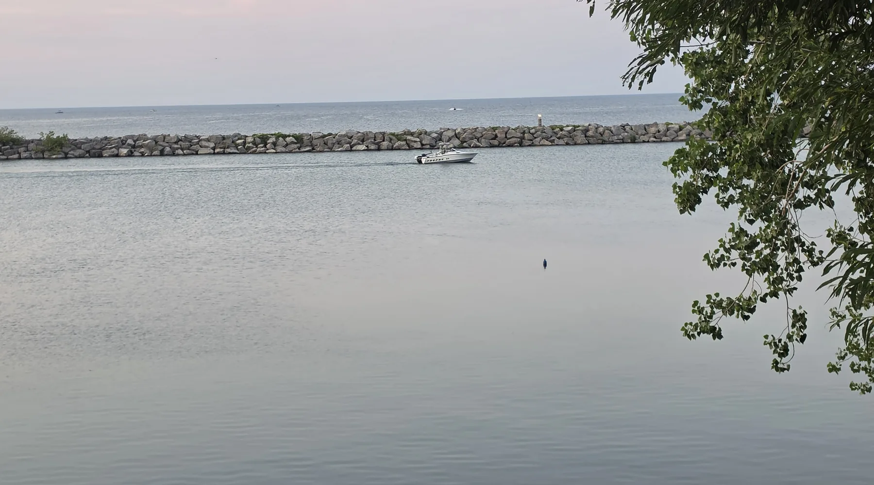 Ontario harbour breakwall and boat on calm water